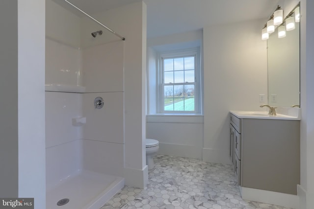 bathroom with tile patterned floors, vanity, toilet, and a shower