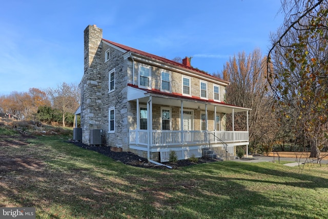 view of front facade featuring covered porch, central air condition unit, and a front lawn