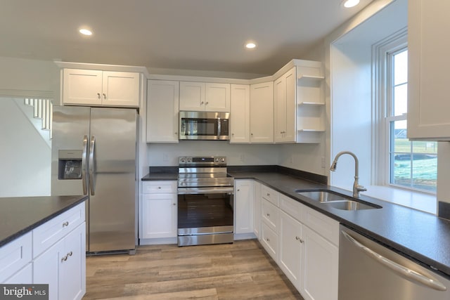 kitchen featuring a wealth of natural light, white cabinetry, sink, and appliances with stainless steel finishes