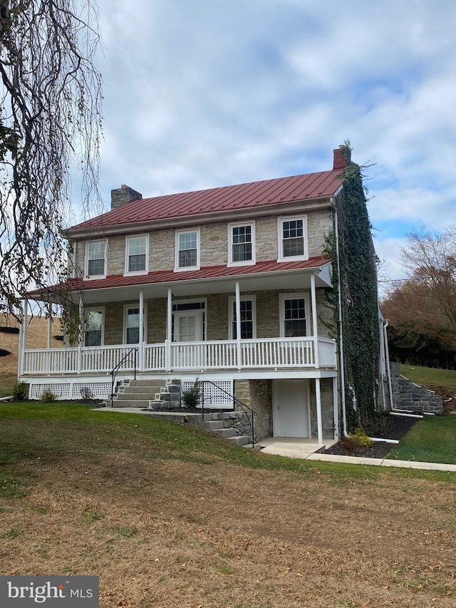 view of front of home with a front yard and a porch