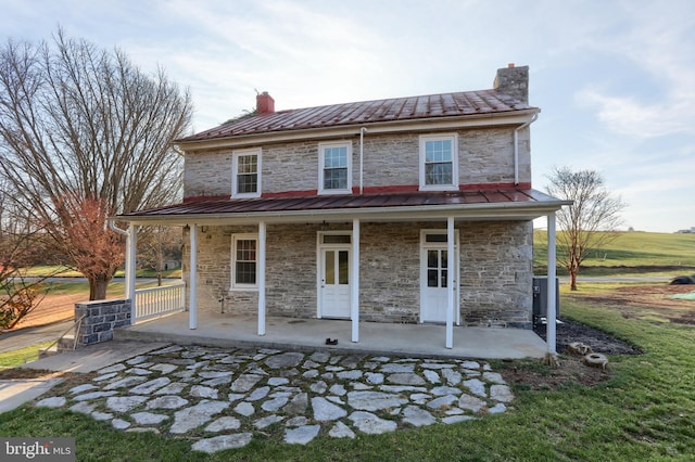 rear view of property featuring covered porch