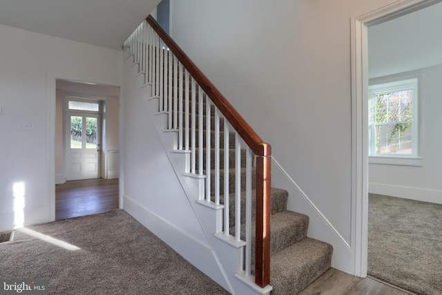 staircase featuring a wealth of natural light and hardwood / wood-style flooring