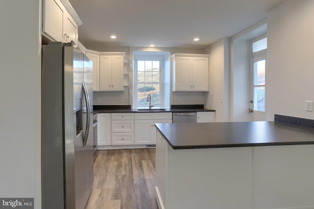 kitchen with white cabinets, sink, kitchen peninsula, and stainless steel appliances