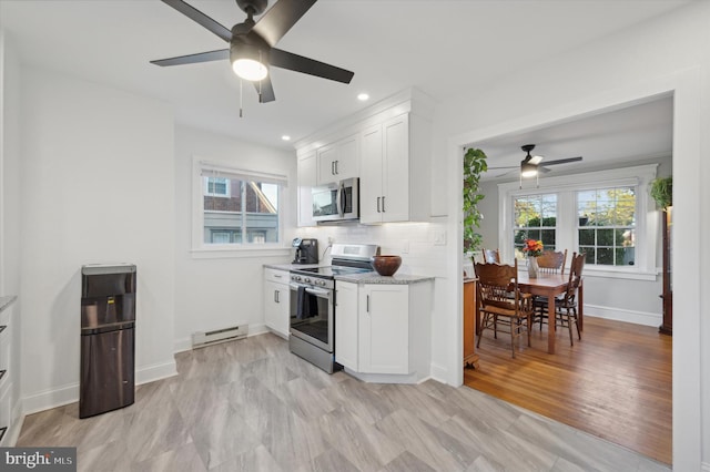 kitchen with white cabinets, a healthy amount of sunlight, and stainless steel appliances