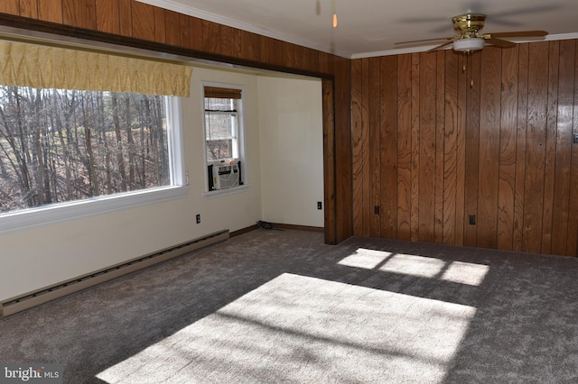 unfurnished room featuring ceiling fan, dark carpet, ornamental molding, and a baseboard heating unit