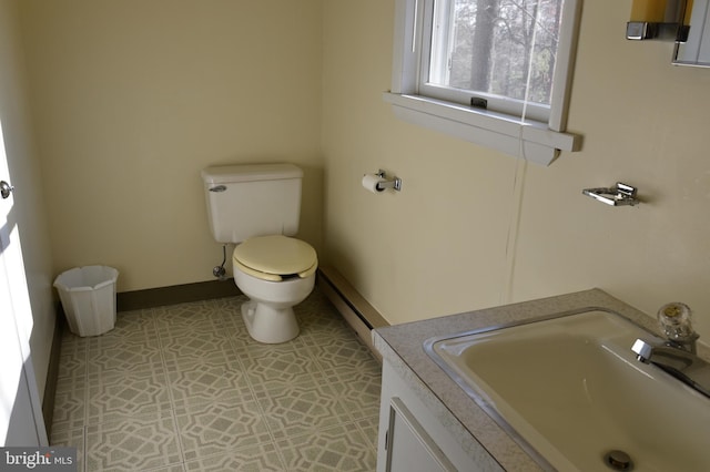 bathroom featuring tile patterned floors, vanity, toilet, and baseboard heating