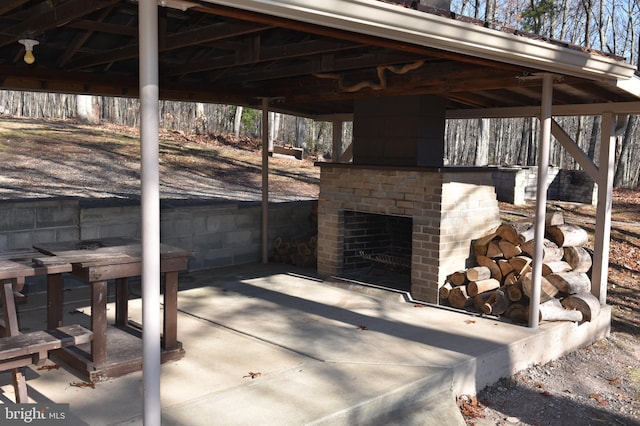 view of patio / terrace featuring a gazebo and an outdoor brick fireplace