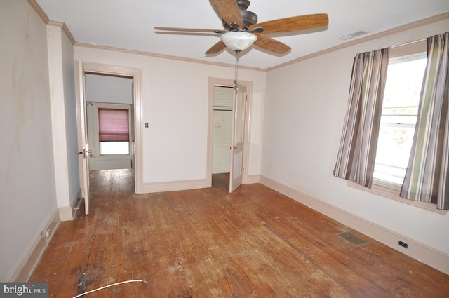 unfurnished bedroom featuring ceiling fan, a closet, crown molding, and hardwood / wood-style flooring