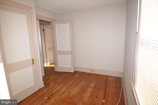 unfurnished bedroom with hardwood / wood-style flooring and multiple windows