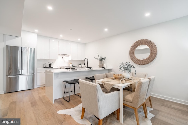 dining space with light hardwood / wood-style flooring and sink