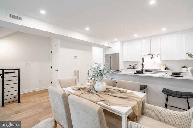 dining area featuring light hardwood / wood-style floors and sink