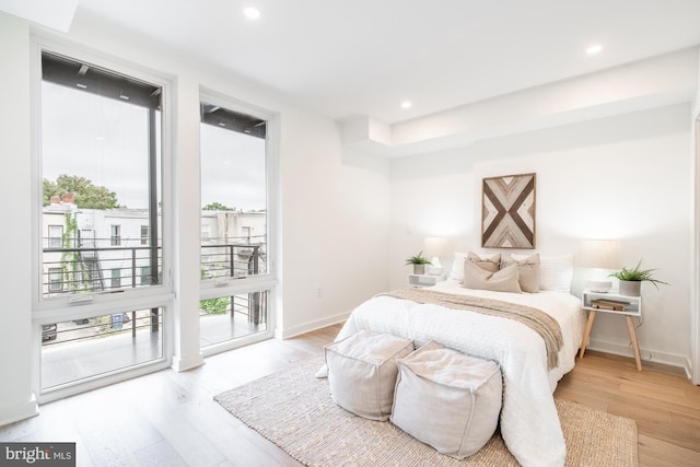 bedroom with access to exterior and light hardwood / wood-style flooring