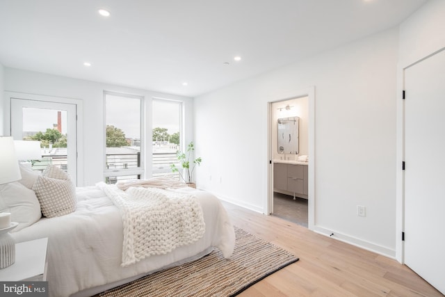 bedroom with connected bathroom and light wood-type flooring