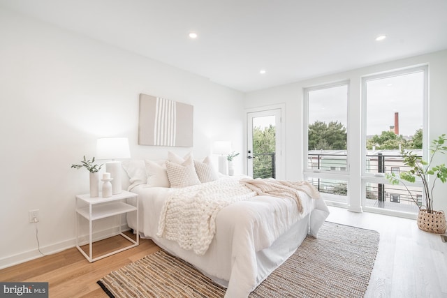 bedroom with access to exterior and light hardwood / wood-style flooring