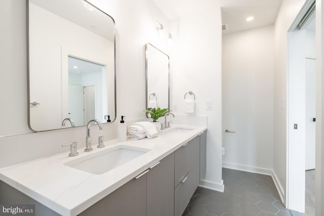 bathroom with toilet, vanity, and tile patterned floors