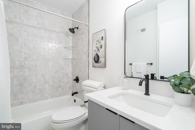 full bathroom with vanity, tiled shower / bath combo, and toilet