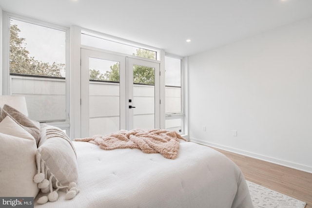 bedroom with access to outside, light hardwood / wood-style flooring, and french doors