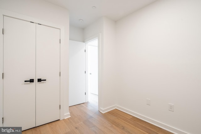 unfurnished bedroom featuring a closet and light wood-type flooring