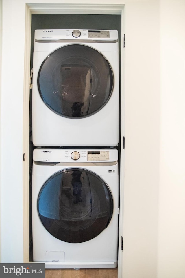 clothes washing area featuring stacked washer and dryer