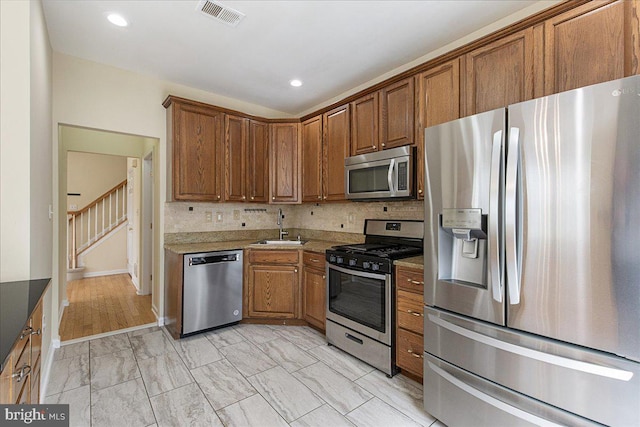 kitchen featuring backsplash, stainless steel appliances, and sink