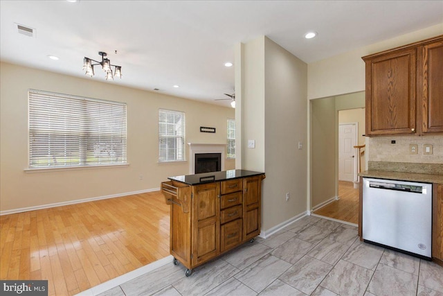 kitchen with tasteful backsplash, ceiling fan, dishwasher, and light hardwood / wood-style flooring