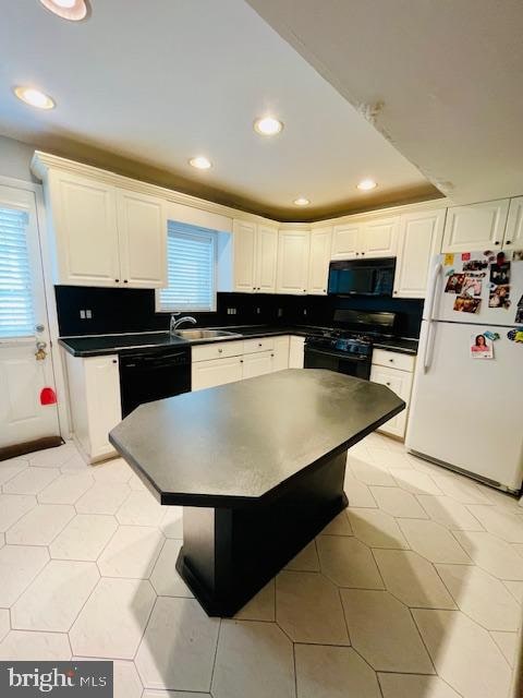 kitchen featuring white cabinets, sink, tasteful backsplash, and black appliances