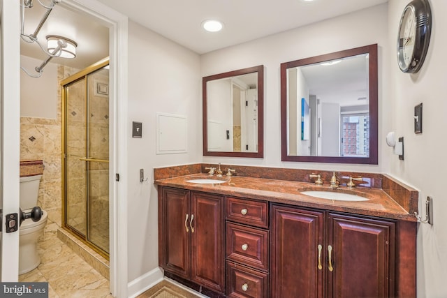 bathroom featuring vanity, toilet, and a shower with shower door