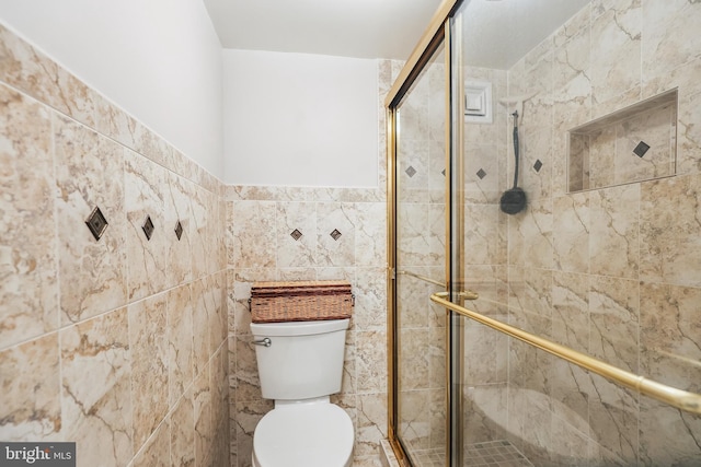 bathroom with tile walls, an enclosed shower, and toilet