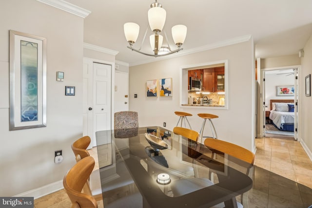 dining room with light tile patterned flooring, ornamental molding, and a chandelier