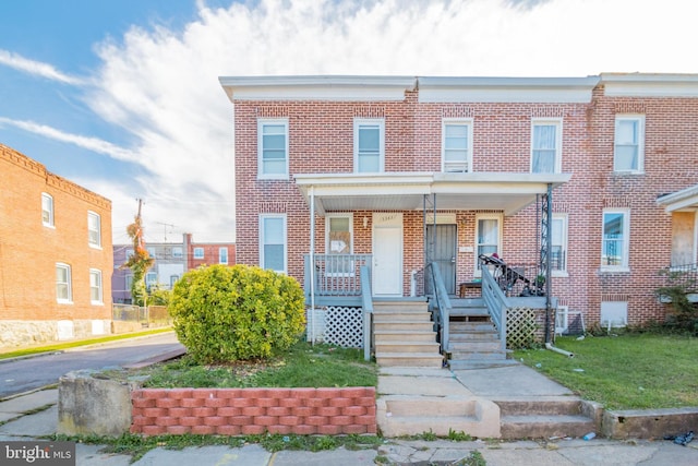 townhome / multi-family property with a porch and a front lawn