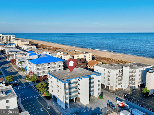 drone / aerial view with a water view and a beach view