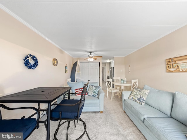 carpeted living room with ceiling fan and ornamental molding