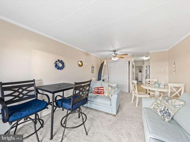 living room with crown molding, ceiling fan, and light colored carpet