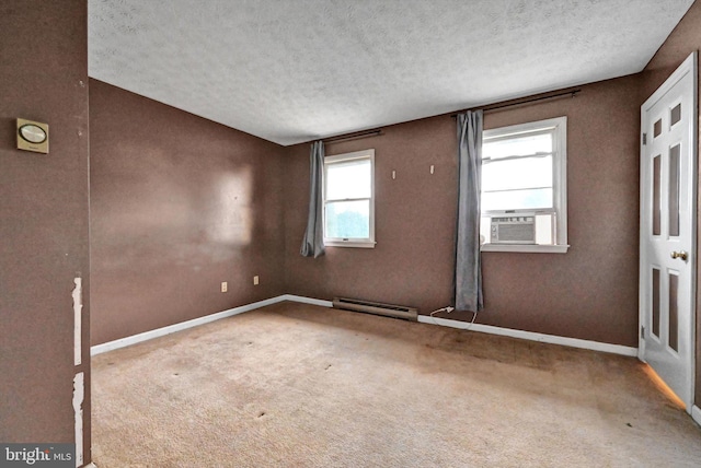 spare room with carpet flooring, a textured ceiling, and a baseboard heating unit