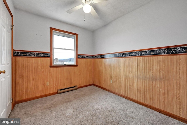 carpeted spare room featuring vaulted ceiling, ceiling fan, a baseboard radiator, and a textured ceiling