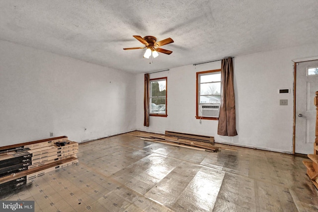 spare room with a textured ceiling, cooling unit, a baseboard heating unit, ceiling fan, and hardwood / wood-style flooring