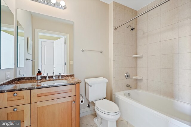 full bathroom featuring tile patterned flooring, tiled shower / bath combo, toilet, and vanity