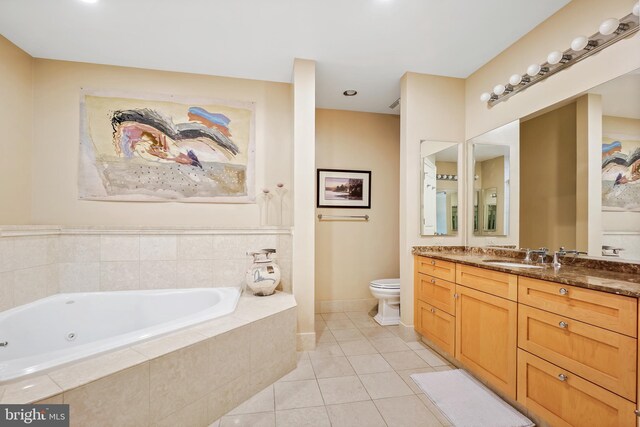 bathroom featuring tile patterned flooring, vanity, toilet, and tiled tub