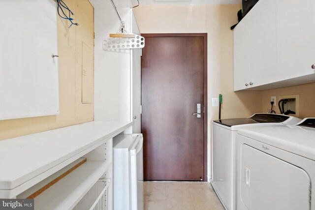 laundry area featuring cabinets, independent washer and dryer, and light tile patterned floors