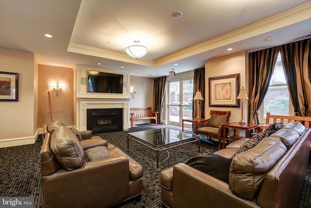 carpeted living room with a raised ceiling and ornamental molding