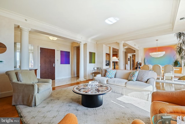 living room featuring ornamental molding, light hardwood / wood-style floors, and a notable chandelier