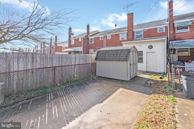 rear view of house with a storage unit