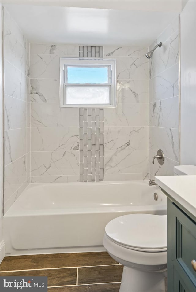 full bathroom featuring toilet, vanity, and tiled shower / bath