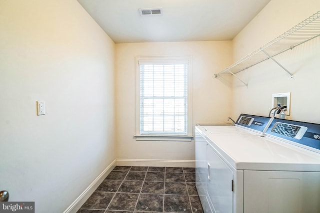 washroom featuring washing machine and dryer and dark tile patterned floors