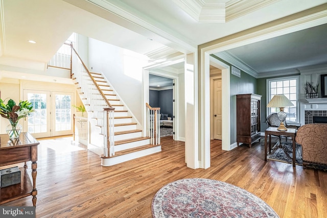 interior space with plenty of natural light, wood-type flooring, french doors, and ornamental molding