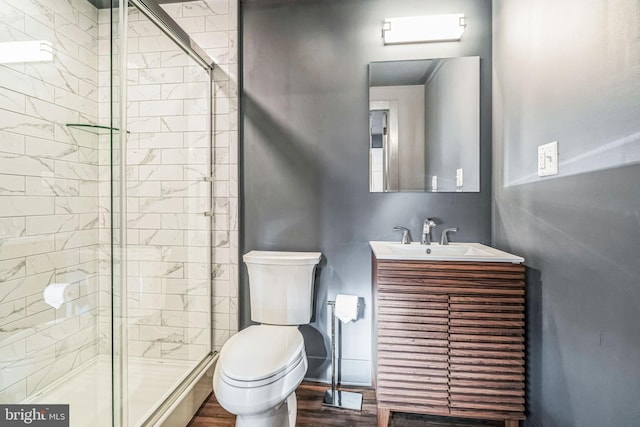 bathroom featuring hardwood / wood-style floors, vanity, toilet, and walk in shower