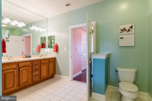 bathroom with tile patterned flooring, vanity, and toilet