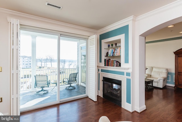 entryway with dark hardwood / wood-style flooring, built in features, and crown molding