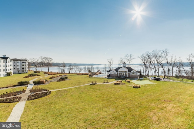 view of home's community with a lawn and a water view