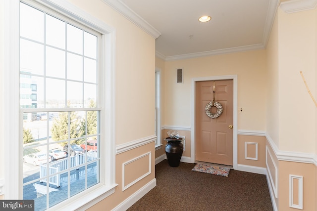 doorway to outside with dark carpet and crown molding